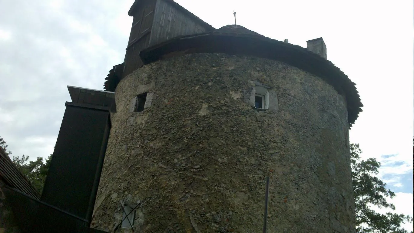 Das Bruchsteinmauerwerk des Turms mit Schindeldach und Holzgaube.