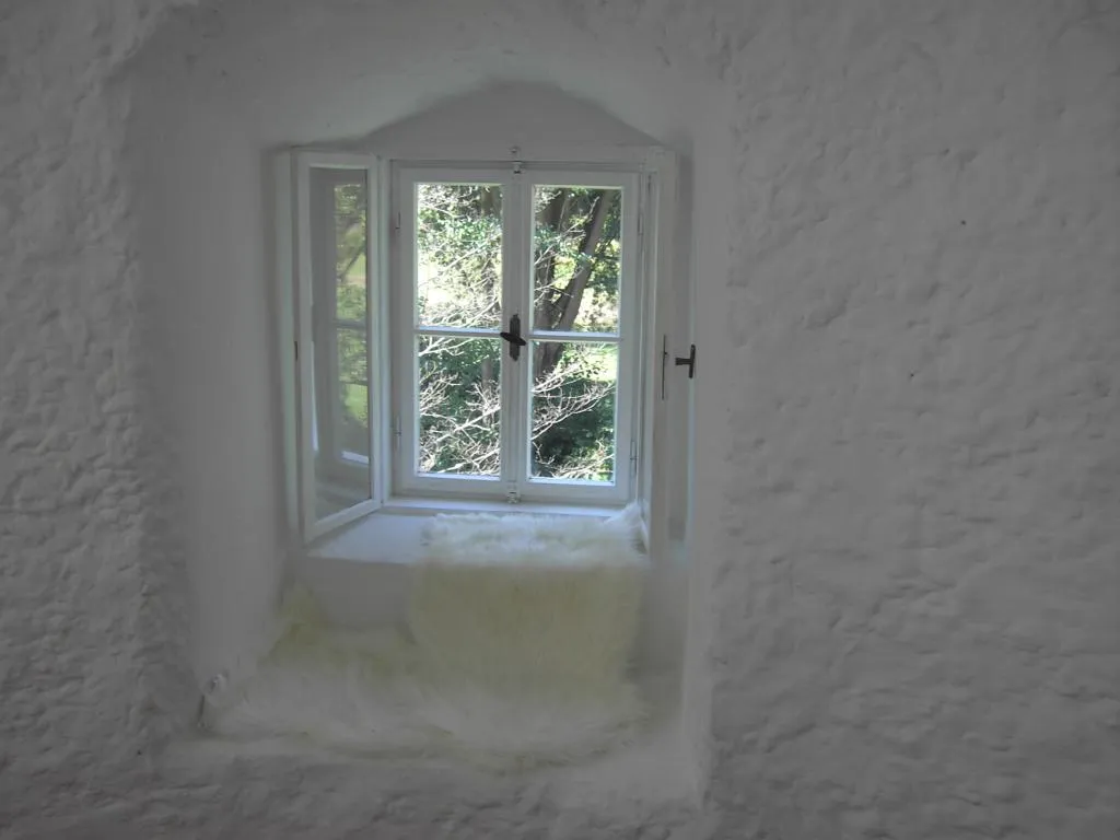 Fenstersitz in der Lounge — die Nische in der Turmmauer ist tief genug zum Sitzen, ausgelegt mit Schaffellen.